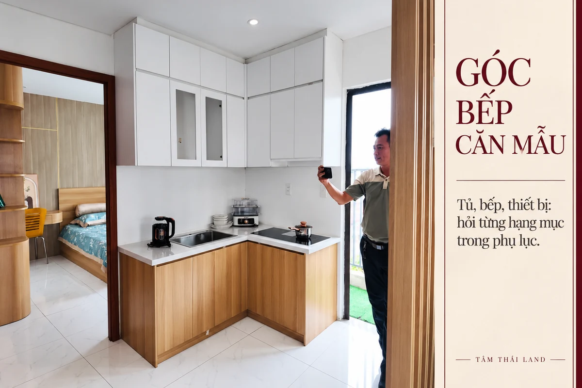 Góc bếp tủ trắng gỗ trong căn mẫu Nhà ở xã hội Thăng Long, có người tham quan đứng cạnh cửa.