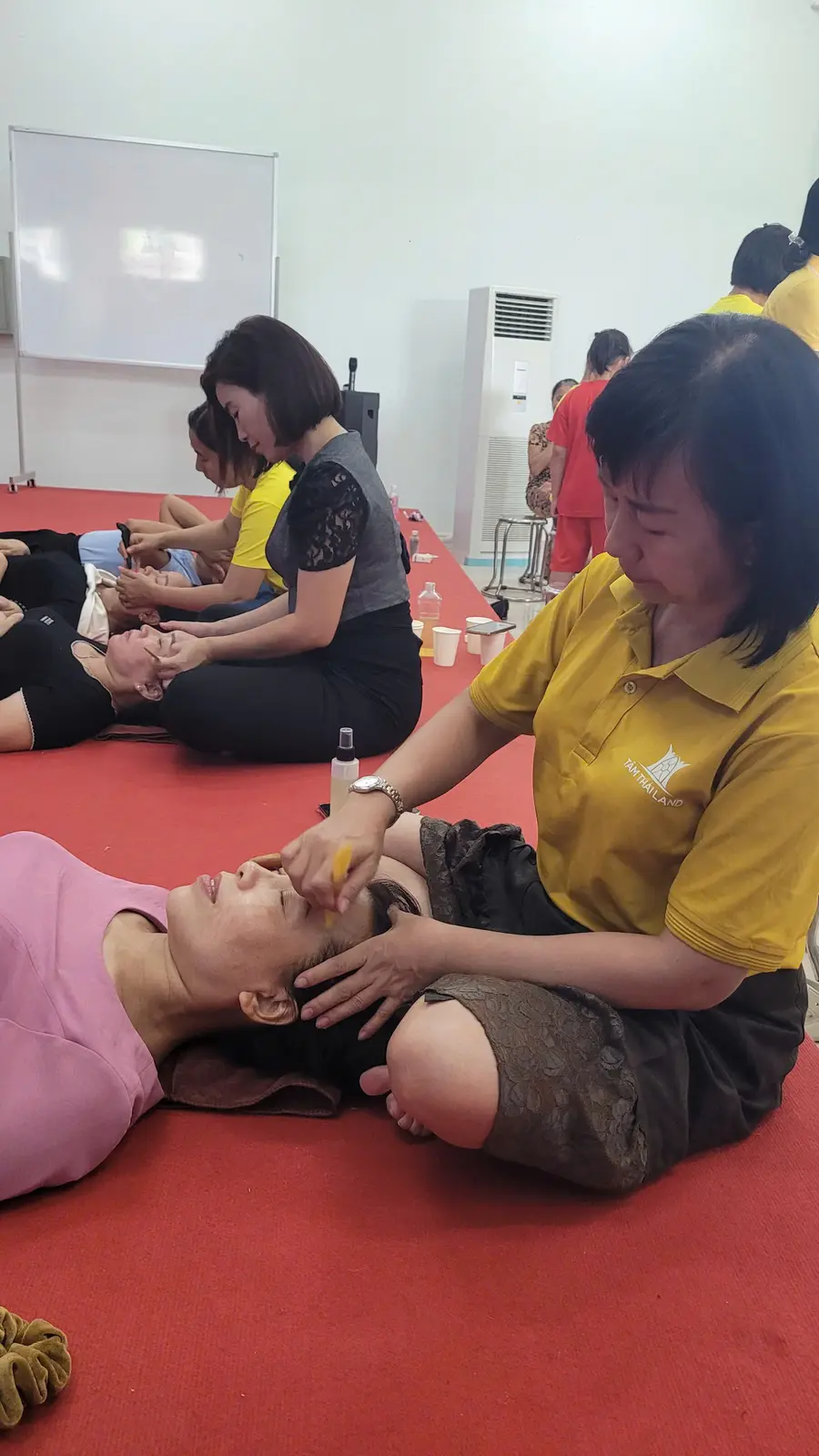 Tình nguyện viên hỗ trợ thư giãn cho người tham dự buổi chăm sóc sức khỏe cộng đồng